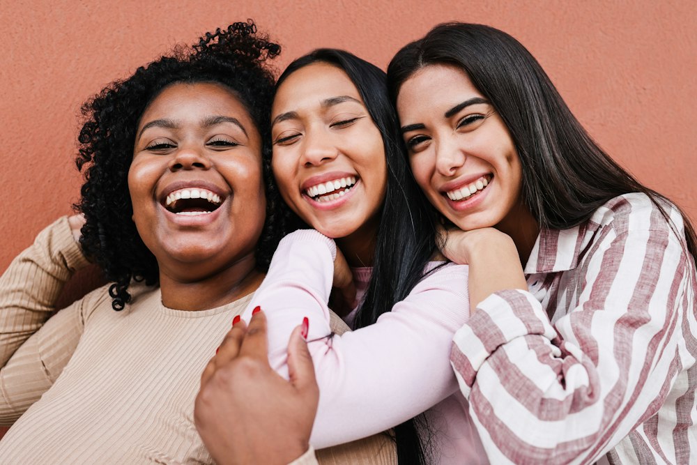 Three friends hugging and laughing